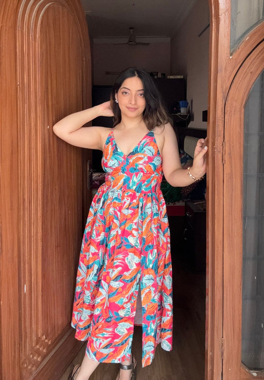 Woman in a colorful dress standing in a doorway.